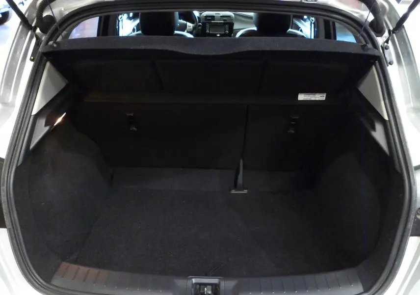 Coffre ouvert d'une Nissan Pulsar gris glacier de 2019, vue arrière montrant l'espace de chargement vide et l'intérieur noir.