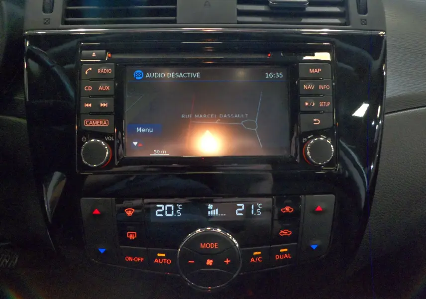 Tableau de bord de Nissan Pulsar 2019 avec écran GPS et commandes de climatisation numériques en intérieur noir brillant.