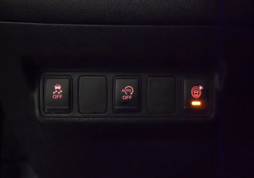Panneau de commandes intérieures avec boutons d'assistance et verrouillage éclairés sur Nissan Pulsar gris Glacier 2019.