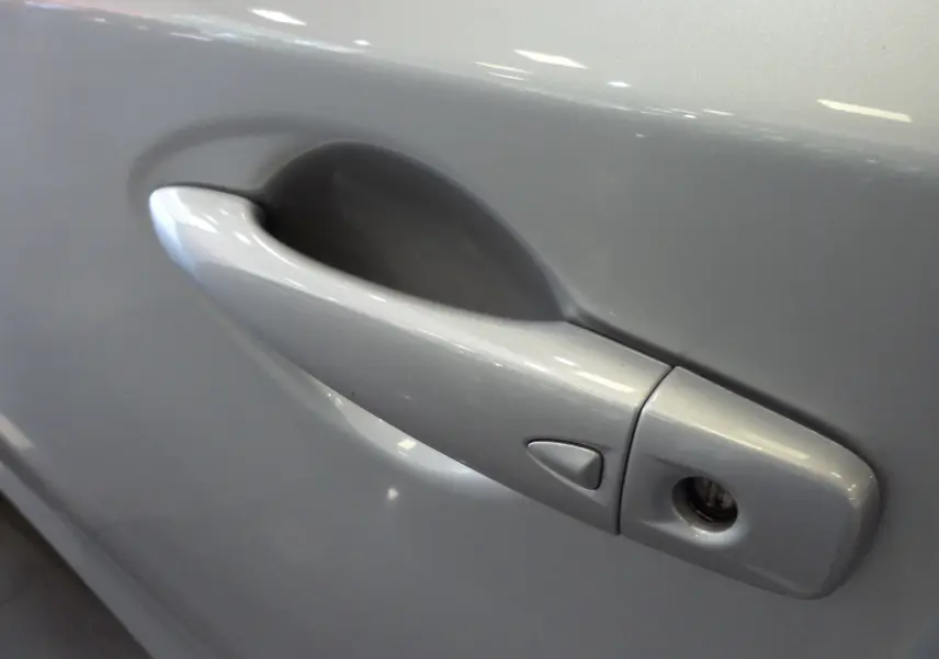 Poignée de porte gris glacier de la Nissan Pulsar 2019, vue rapprochée côté gauche avec serrure visible.