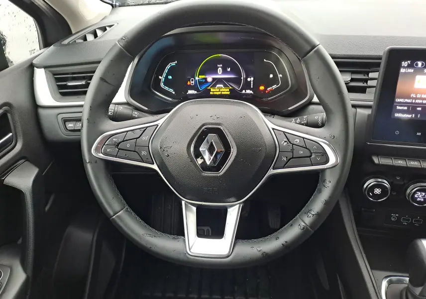Vue centrée sur le volant noir du Renault Captur 1.6 E-Tech Hybrid 2022 avec tableau de bord numérique et commandes intégrées.