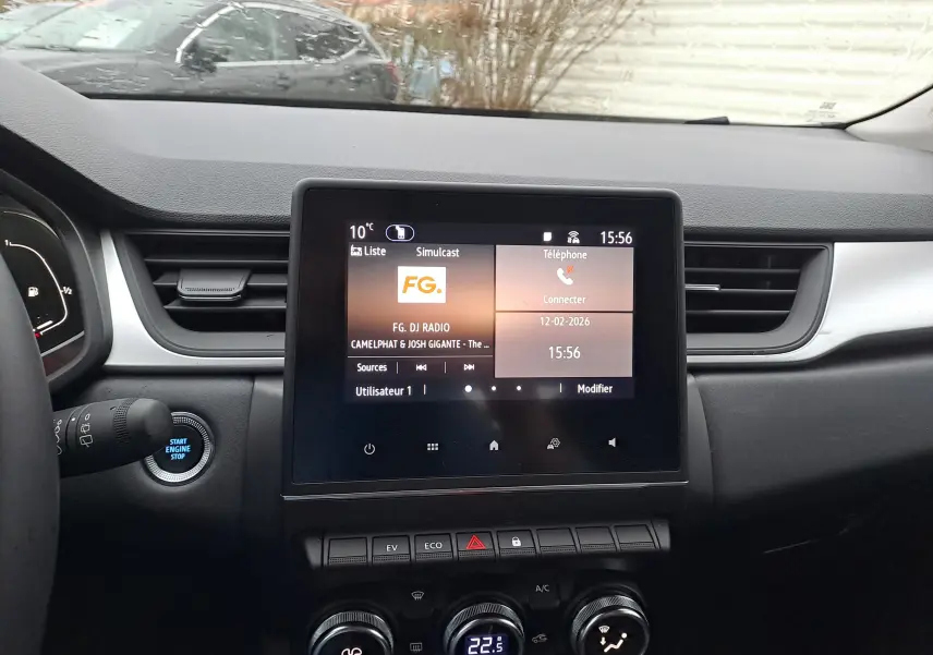 Vue intérieure du tableau de bord du Renault Captur gris cassiopée, avec écran tactile central et commandes de climatisation.