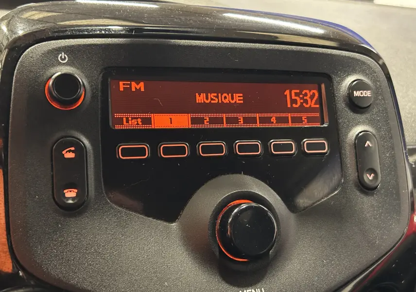 Gros plan sur la radio FM rouge et noire du tableau de bord de la Citroën C1 Airscape VTi 72 Feel 2019.