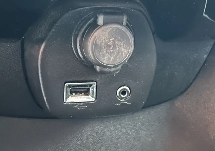 Gros plan sur la prise USB et la prise jack audio du tableau de bord d'une Citroën C1 rouge de 2019.