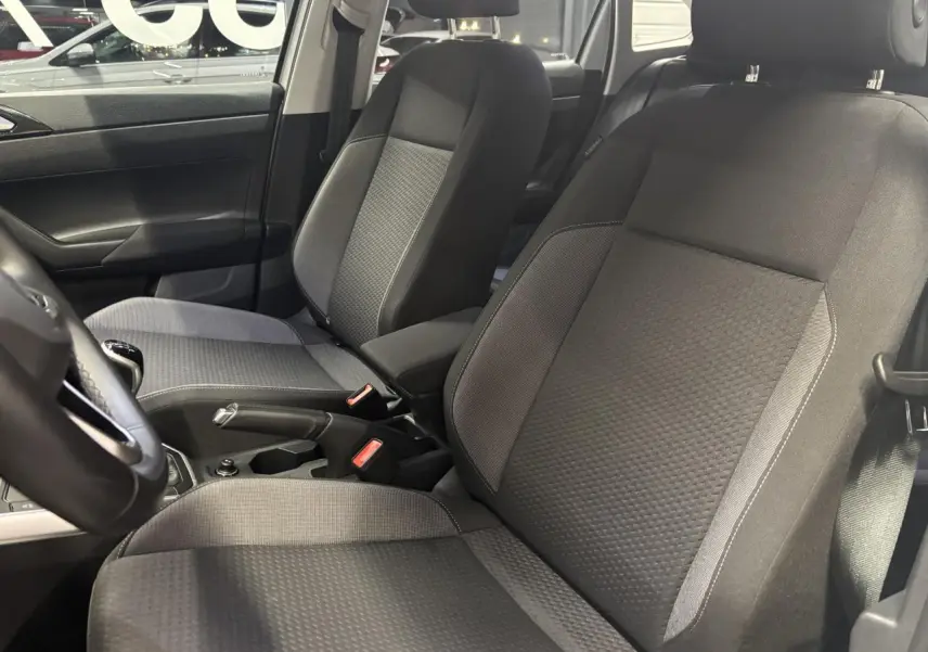 Vue intérieure côté gauche montrant les sièges avant en tissu gris foncé du Volkswagen Taigo 2023.