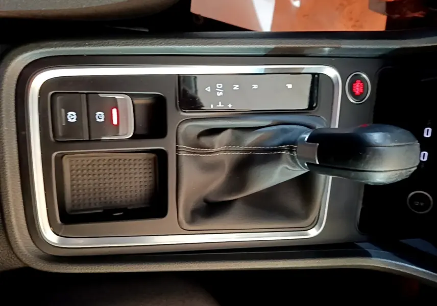 Gros plan sur la console centrale avec levier de vitesse automatique et bouton de frein à main électrique du SEAT Ateca gris clair.