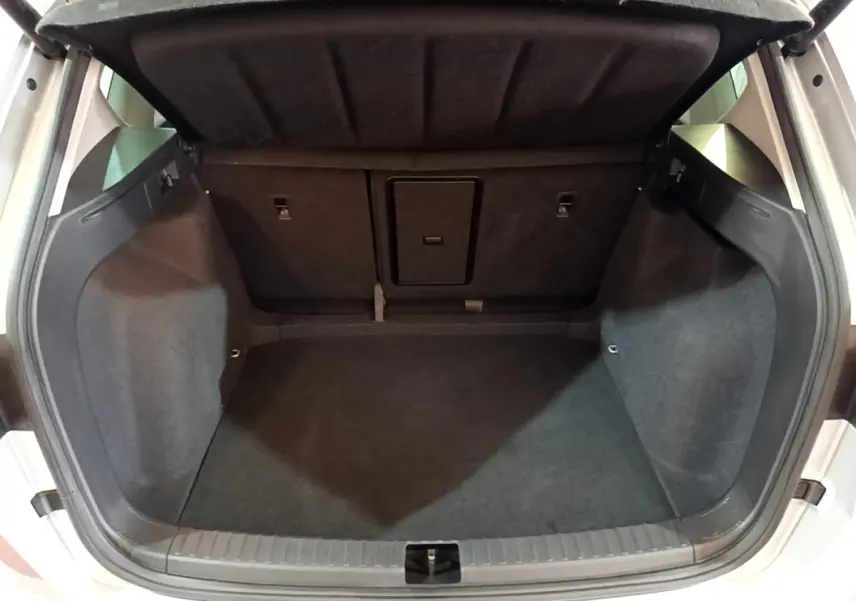 Coffre ouvert vu de l'arrière d'un SEAT Ateca gris clair, espace de chargement vide et revêtement noir.
