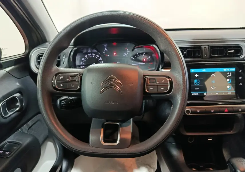 Vue intérieure centrée sur le volant multifonctions noir d'une Citroën C3 2024 avec tableau de bord et écran tactile.