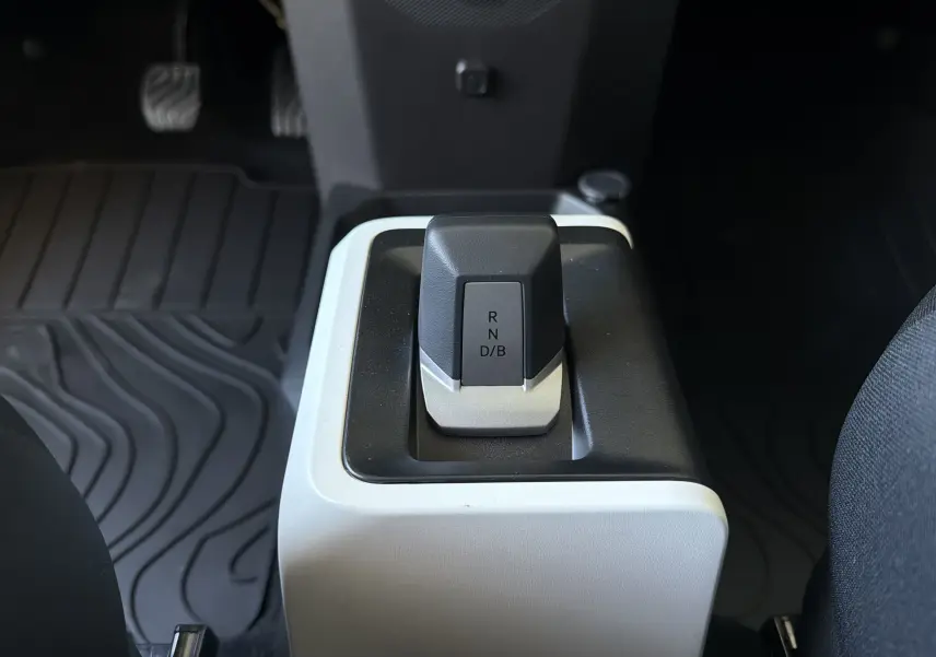 Le levier de vitesses automatique noir et gris de la Dacia Spring 65 Extreme, vu de dessus dans l'habitacle.