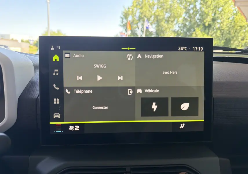 Écran tactile central de la Dacia Spring 65 Extreme beige Safari, affichant les menus audio, navigation et véhicule.