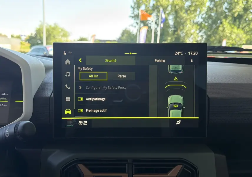 Vue intérieure centrée sur l'écran tactile du tableau de bord du Dacia Spring 65 Extreme, affichant les options de sécurité.