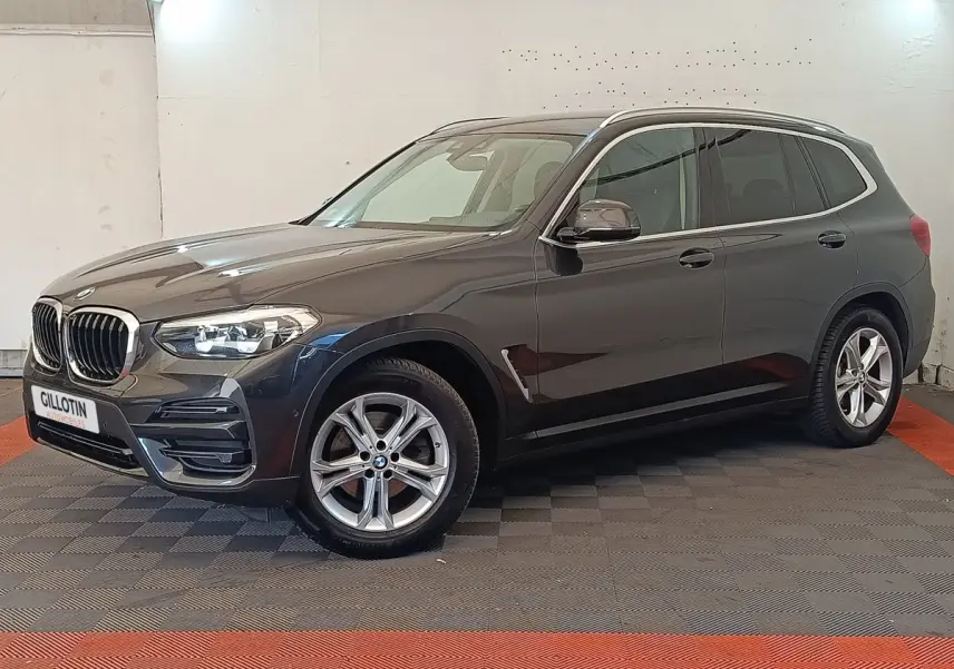 BMW X3 xDrive20d gris clair vu de profil droit en intérieur avec jantes alliage et calandre caractéristique BMW.