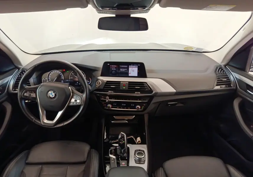 Vue intérieure avant du tableau de bord et volant cuir alu multifonctions de la BMW X3 gris clair 2020 xDrive20d.
