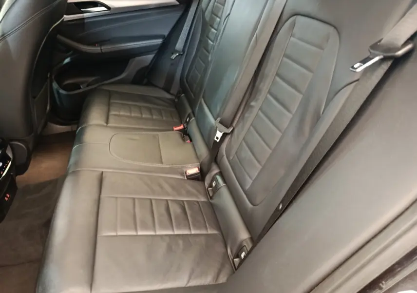 Vue rapprochée de la banquette arrière en cuir noir de la BMW X3 xDrive20d, soulignant les détails des sièges et ceintures.