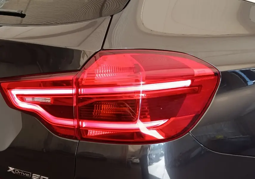 Gros plan sur le feu arrière droit rouge d’un BMW X3 gris clair xDrive20d 2020 avec logo visible.