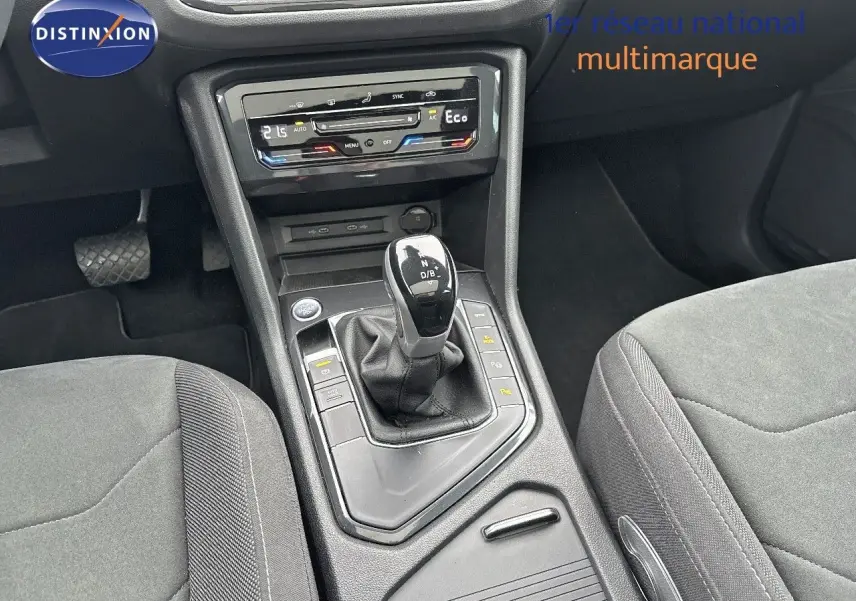 Vue rapprochée de la console centrale du Volkswagen Tiguan 1.4 E-HYBRID 2022 avec levier de vitesses automatique et commandes climatisation.