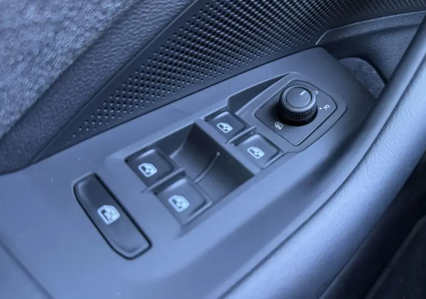 Commande des vitres et réglage des rétroviseurs côté gauche intérieur d'une Volkswagen Passat SW noire 2024