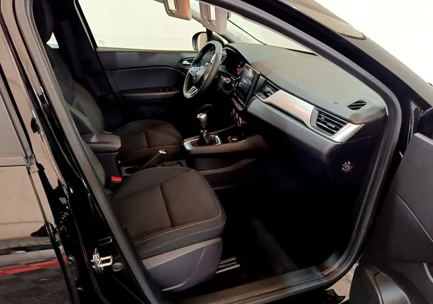 Intérieur noir de la Renault Captur Business TCe 90 2021 vu côté conducteur, avec tableau de bord et écran tactile central.