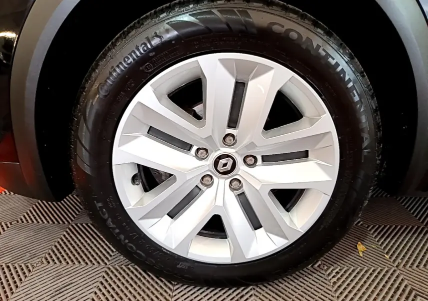 Gros plan sur la roue arrière droite d'un Renault Captur noir 2021 avec jante et pneu Continental visibles.