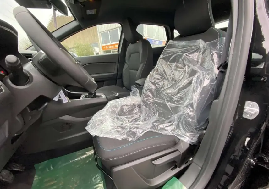 Vue intérieure côté conducteur du Renault Captur noir étoilé 2025, siège avant protégé par film plastique.