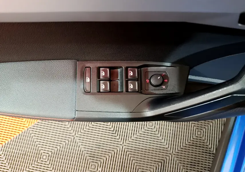 Détail des commandes des vitres et rétroviseurs sur la porte côté gauche d'un SEAT Arona bleu 2022.