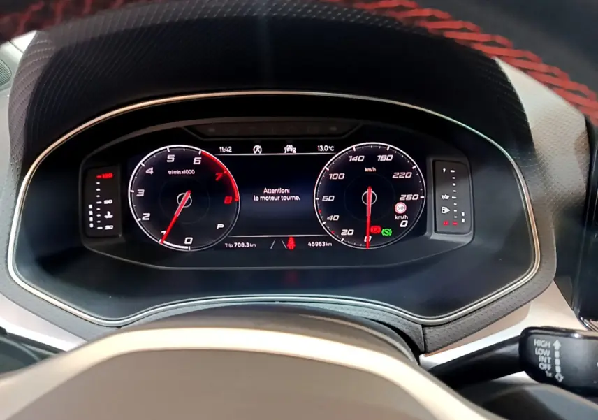 Vue rapprochée du tableau de bord digital du SEAT Arona 2022, affichage vitesse et compte-tours avec message moteur.