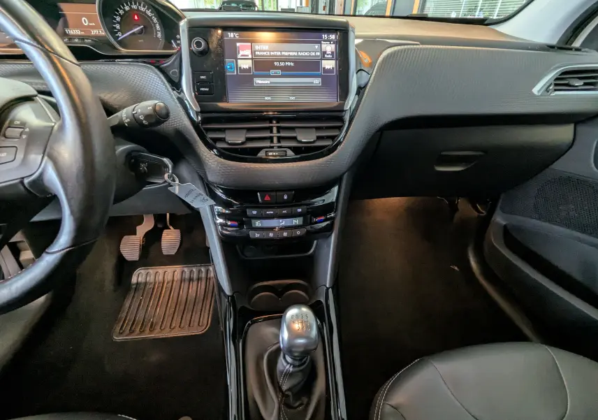 Vue intérieure avant centrée sur la console et levier de vitesses manuelle du Peugeot 2008 blanc de 2017.