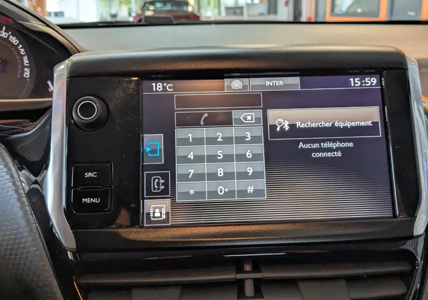 Vue rapprochée de l'écran tactile central du tableau de bord du Peugeot 2008 blanc, affichant le menu téléphone.
