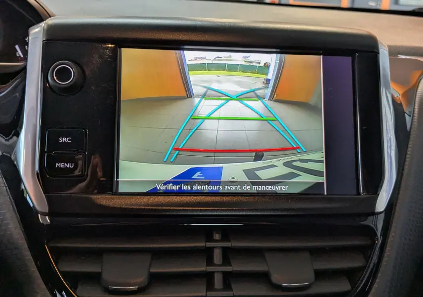 Écran de caméra de recul du Peugeot 2008 blanc montrant les lignes d’aide au stationnement en intérieur.