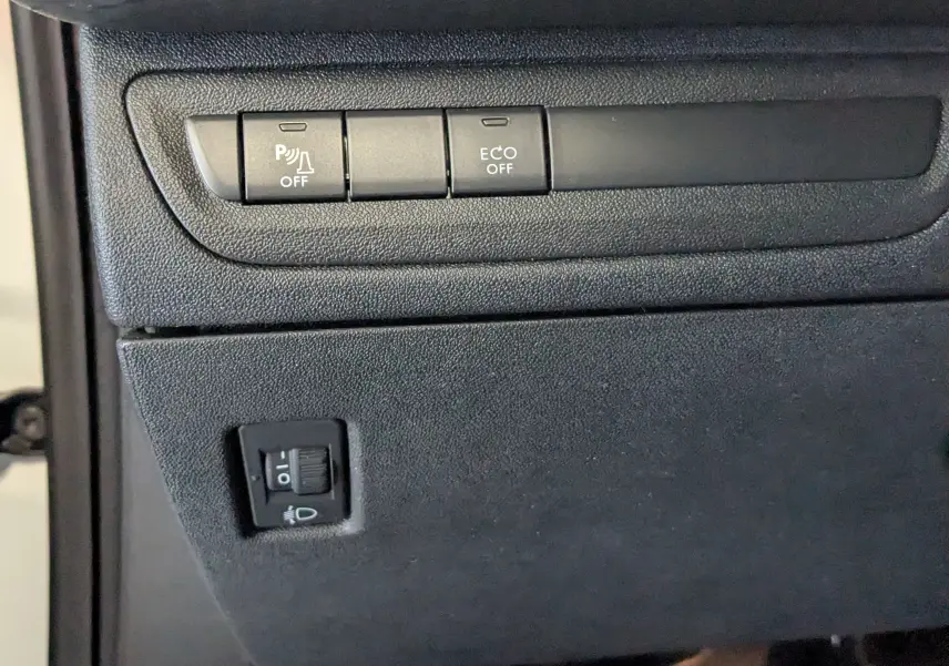 Gros plan sur les boutons de commande noirs du tableau de bord du Peugeot 2008 blanc, version 1.6 20ch allure.