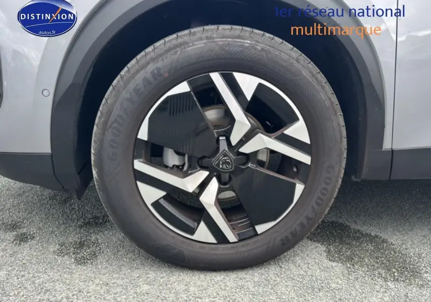 Gros plan sur la roue avant droite du Peugeot 2008 gris artense, mettant en valeur la jante alu au design moderne.