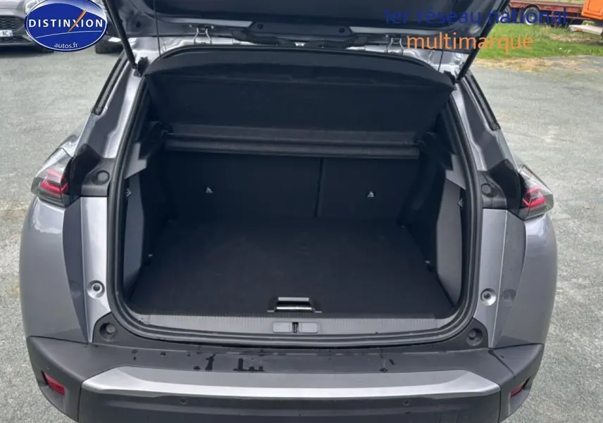Coffre ouvert vu de l'arrière d'un Peugeot 2008 gris artense avec feux arrière à LED visibles.