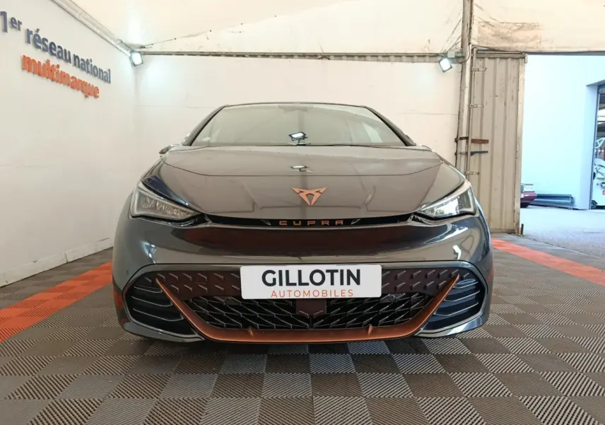 Vue frontale d'une CUPRA BORN gris foncé avec détails cuivrés et logo distinctif sur calandre.