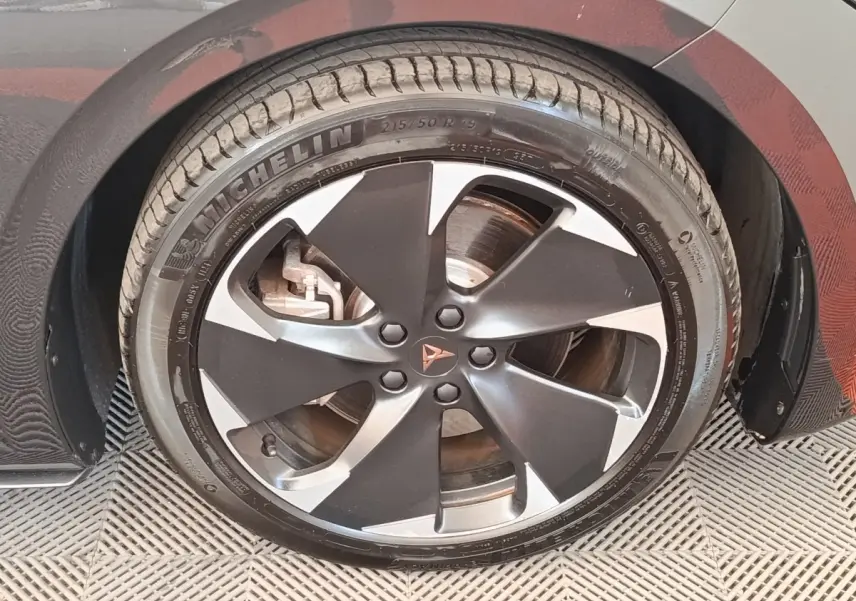 Gros plan sur la roue avant droite gris foncé du CUPRA BORN 230ch avec jante alliage bicolore et logo CUPRA central.