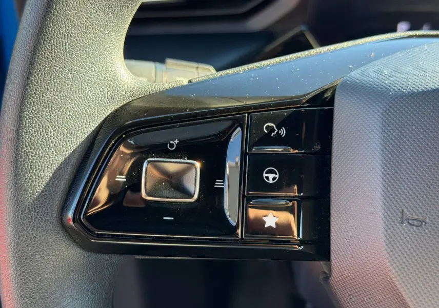 Gros plan sur les commandes multifonctions noires du volant côté gauche du MG3 Como Blue 2025.
