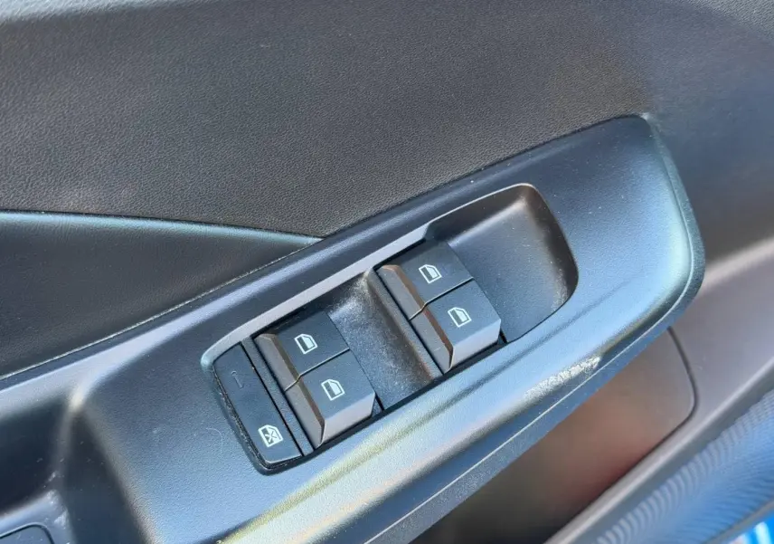 Gros plan sur les commandes des vitres électriques côté gauche d’une MG3 1.5 Hybrid+ 195ch Comfort en Como Blue métallisé.