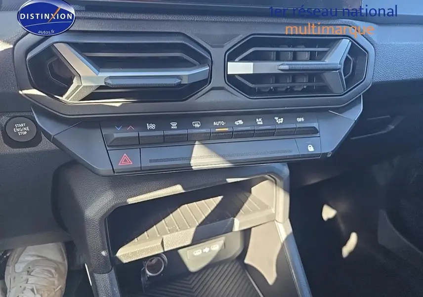 Détail intérieur du tableau de bord du Dacia Duster 2025 avec commandes climatisation et prise USB visibles