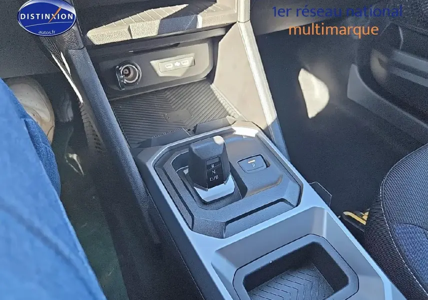 Gros plan sur la console centrale du Dacia Duster 2025 brun terracotta, mettant en valeur le levier de vitesses et les rangements.
