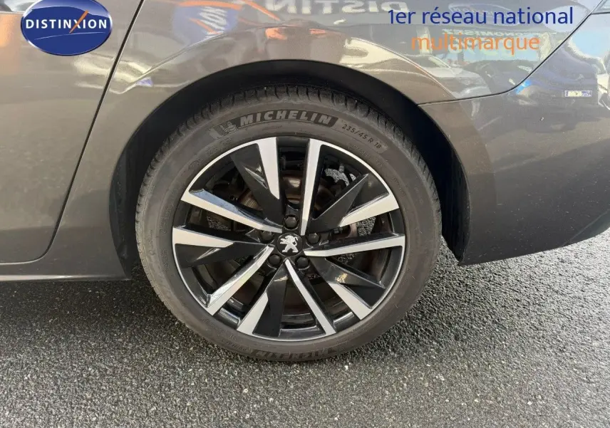 Gros plan sur la roue arrière droite d'une Peugeot 508 gris platinium avec jante alliage noire et argentée.