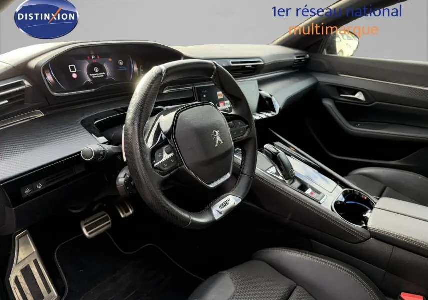 Intérieur côté conducteur du Peugeot 508 gris platinium 2023, tableau de bord moderne et volant sport GT en cuir noir.