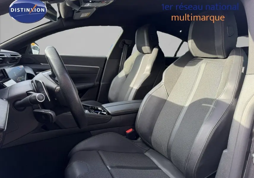 Vue intérieure côté conducteur de la Peugeot 508 gris platinium, mettant en valeur les sièges en cuir et la console centrale moderne.