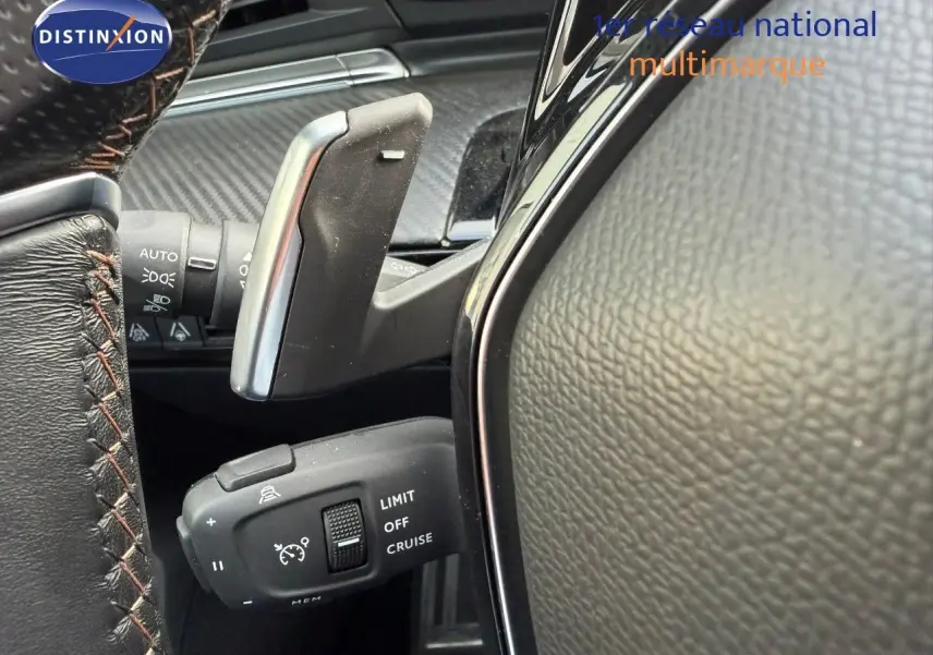 Gros plan sur la commande de régulateur de vitesse et palettes au volant cuir noir sur Peugeot 508 gris platinium.