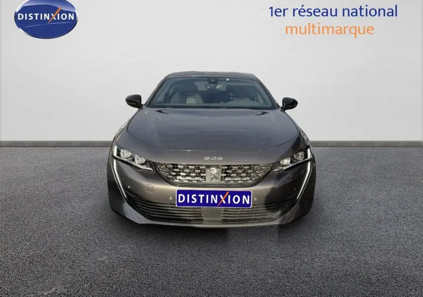 Vue frontale d'une Peugeot 508 gris platinium 2023 avec calandre distinctive et phares LED fins.