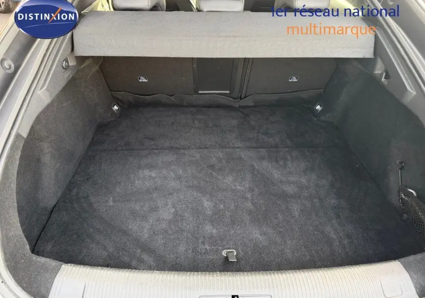 Coffre spacieux et propre de Peugeot 508 gris platinium, vue depuis l'arrière avec cache-bagages déployé.