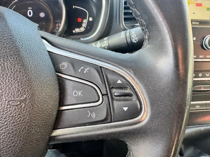 Gros plan sur les commandes au volant cuir noir du Renault Grand Scenic 2019 côté gauche avec tableau de bord en arrière-plan.