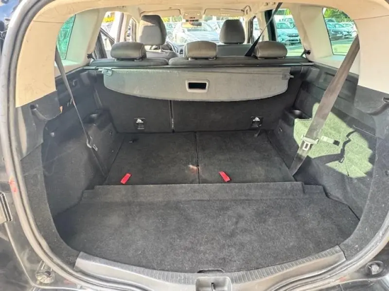 Vue arrière du coffre spacieux noir étoilé du Renault Grand Scenic 2019 avec banquette rabattue et cache-bagages.