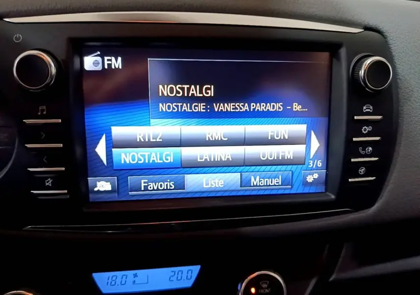 Écran tactile central de la Toyota Yaris 1.5 Hybride 2020 affichant la radio FM avec menu de stations et commandes latérales.