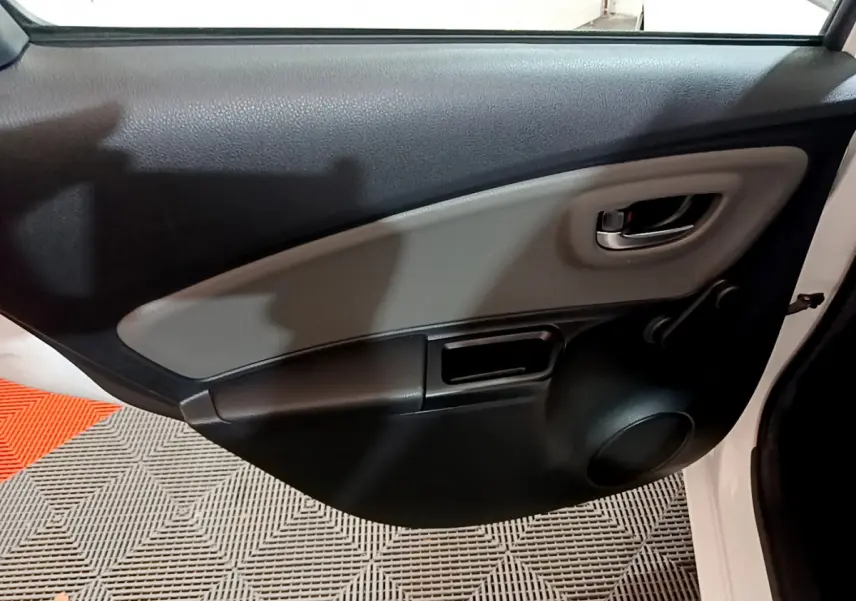 Vue intérieure côté droit de la porte arrière blanche de la Toyota Yaris 1.5 Hybride 2020 avec poignée et haut-parleur intégrés.