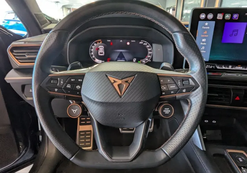 Vue rapprochée du volant noir perforé de la CUPRA Formentor 2.0 TDI 150 DSG7 avec commandes intégrées et tableau de bord numérique.