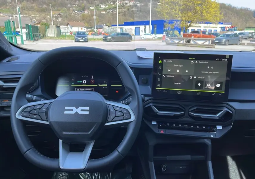 Vue intérieure centrée sur le volant cuir et l’écran tactile 10,1 pouces du tableau de bord du Dacia Bigster 2026.